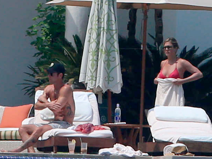 Jennifer Aniston e Justin Theroux se beijam na piscina, em Cabo