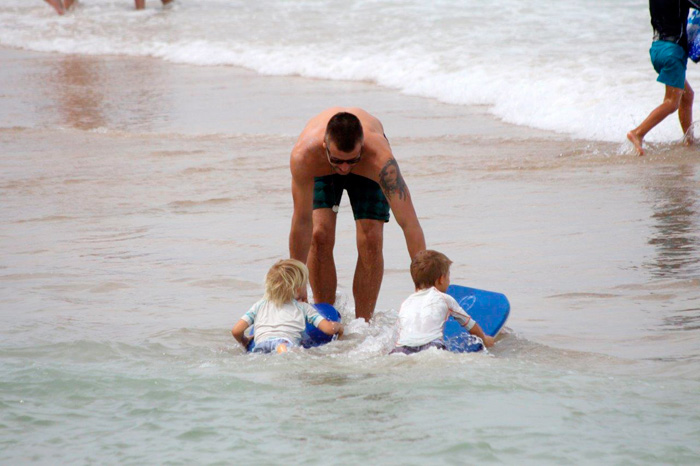 Rodrigo Hilbert ensina os filhos Francisco e João a surfar