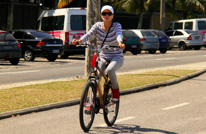 Cássia Kiss Magro descansa em banco de praça após pedalar no RJ