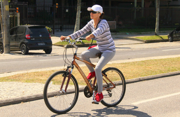 Cássia Kiss Magro descansa em banco de praça após pedalar no RJ