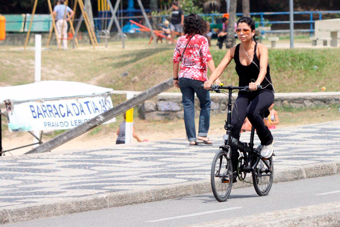 Ana Lima pedala em mini bicicleta pela orla carioca