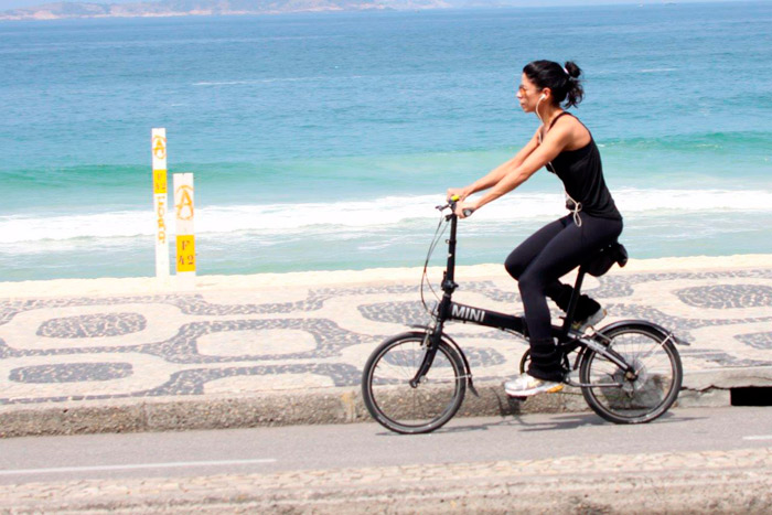 Ana Lima pedala em mini bicicleta pela orla carioca