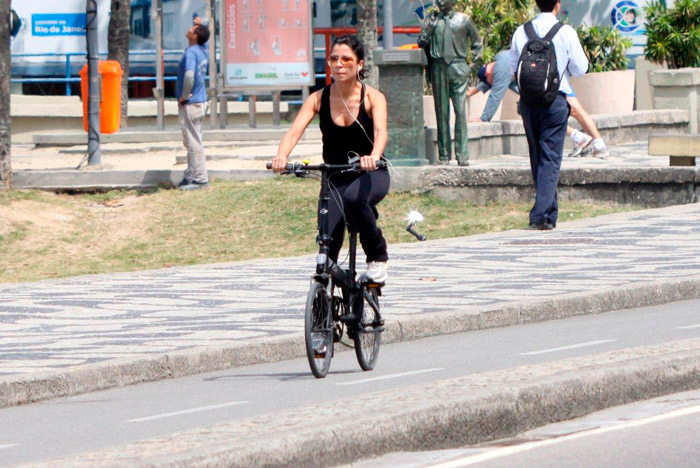 Ana Lima pedala em mini bicicleta pela orla carioca