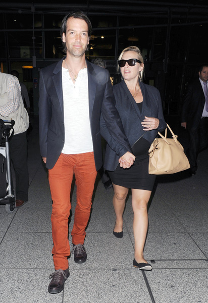 Grávida de seis meses, Kate Winslet é flagrada em aeroporto de Londres com o marido