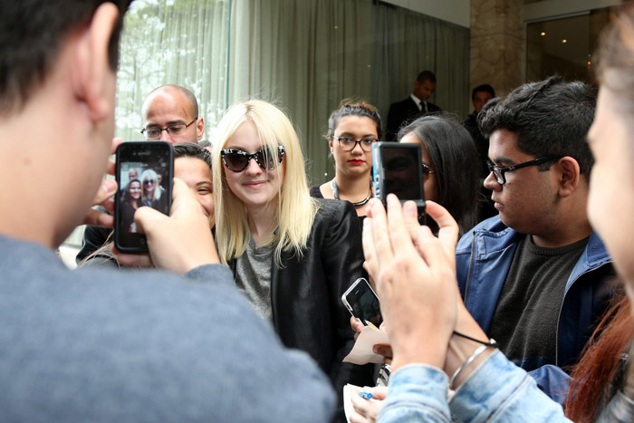 Dakota Fanning atende fãs ao deixar o Rio de Janeiro