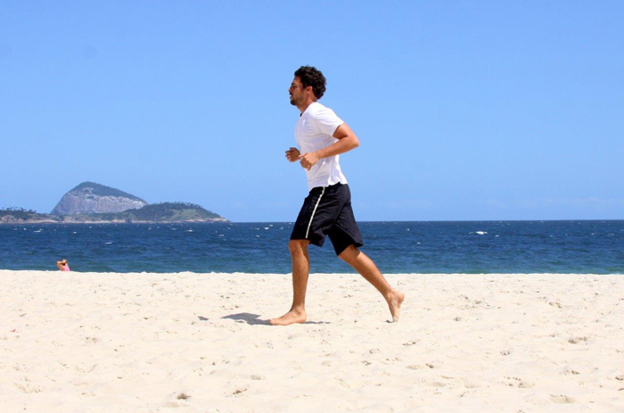 Cauã Reymond corre na praia em tarde de sol no Rio