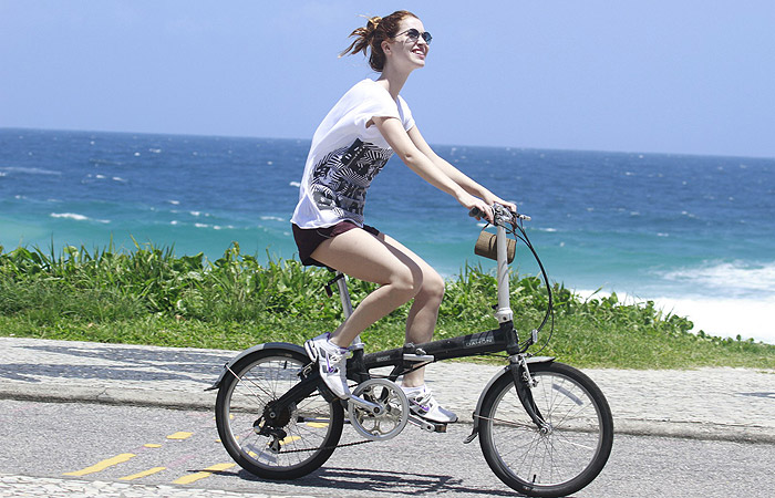 Nathália Dill passeia pela orla ensolarada da Barra