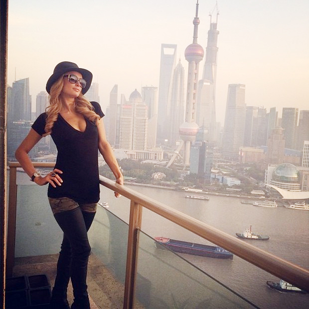 De botas longas e decote generoso, Paris Hilton fotografa em Xangai