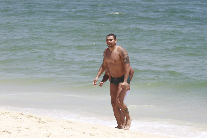 Naldo toma banho de sunga verde e pega sol na praia da Barra