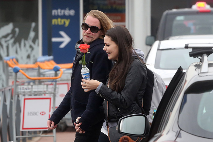 Macaulay Culkin leva rosas para buscar a namorada no aeroporto de Paris