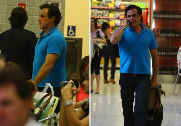 Oscar Magrini acena para os fotógrafos no aeroporto Santos Dumont