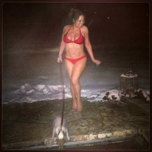 De biquíni, Mariah Carey passeia com o cachorro na neve