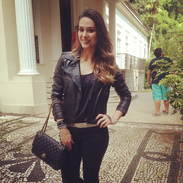 Fernanda Machado grava cena com jaqueta de couro no calor carioca