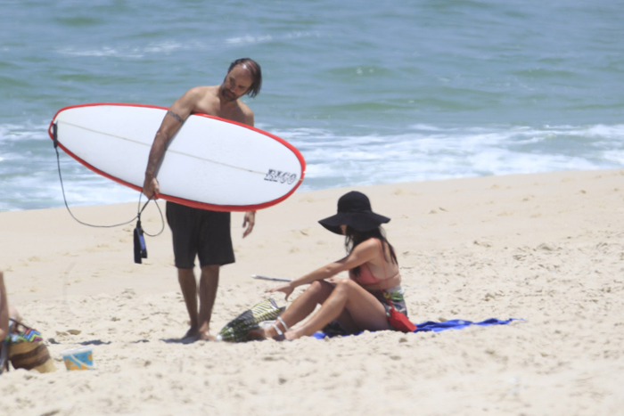 Alinne Moraes usa chapelão para ir à praia com o namorado