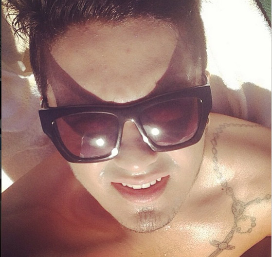 Luan Santana exibe tatuagem tomando sol