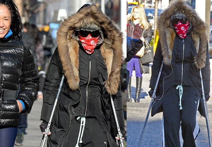 De muletas, Madonna caminha por Nova York cobrindo o rosto com lenço 