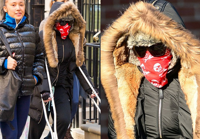 De muletas, Madonna caminha por Nova York cobrindo o rosto com lenço 