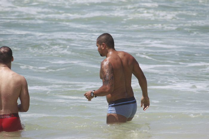 De sunga azul, Naldo se refresca na praia da Barra