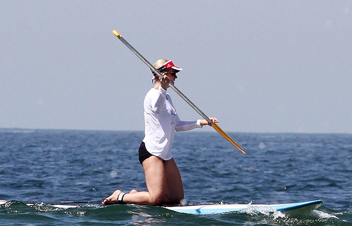 Paula Burlamaqui pratica stand up paddle na praia  
