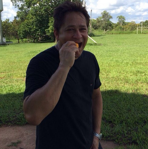 Leonardo come fruta durante caminhada por campo no interior do Goiás