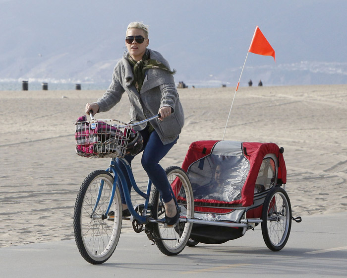 Pink usa espécie de cabana sob rodas para andar de bike com a filha