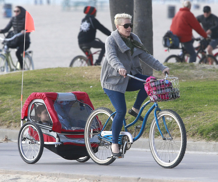 Pink usa espécie de cabana sob rodas para andar de bike com a filha