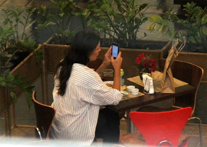 Carolina Ferraz almoça sozinha, em shopping do Rio