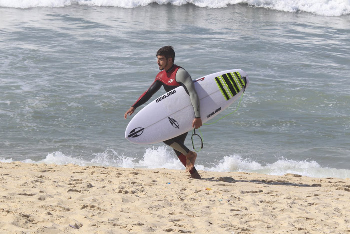 Caio Castro pega onda na praia da Macumba