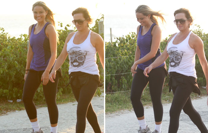 Ellen Roche caminha na praia da Barra da Tijuca com amiga