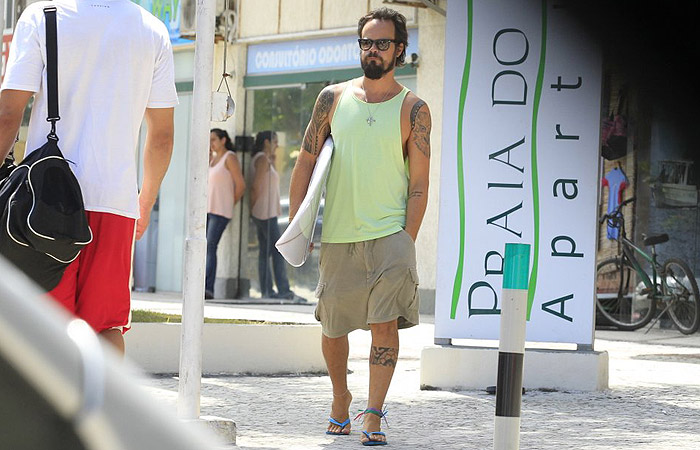 Paulo Vilhena sai de loja de surfe com prancha na mão