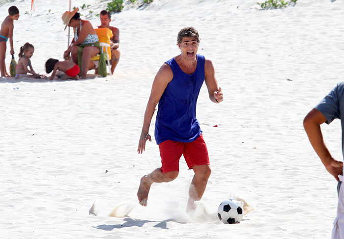 Reynaldo Gianecchini joga futebol na praia durante gravação de Em Família