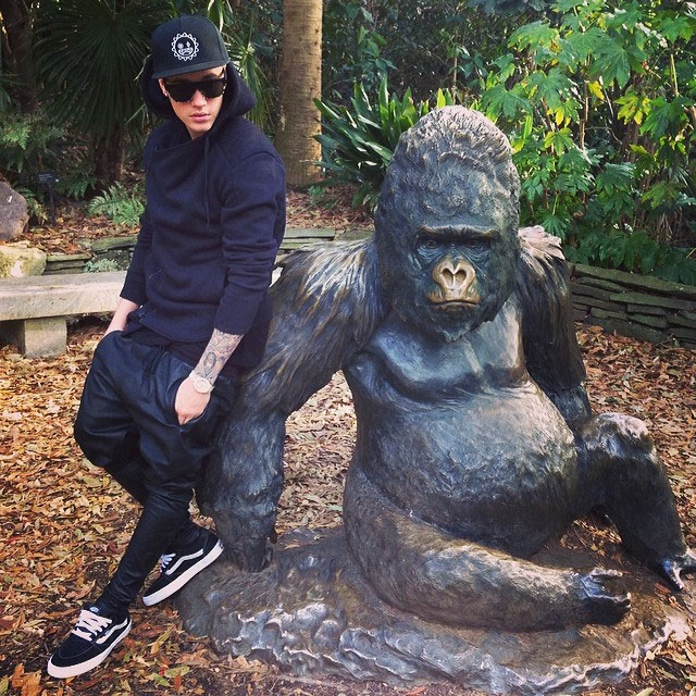 Justin Bieber posa ao lado da estátua de gorila