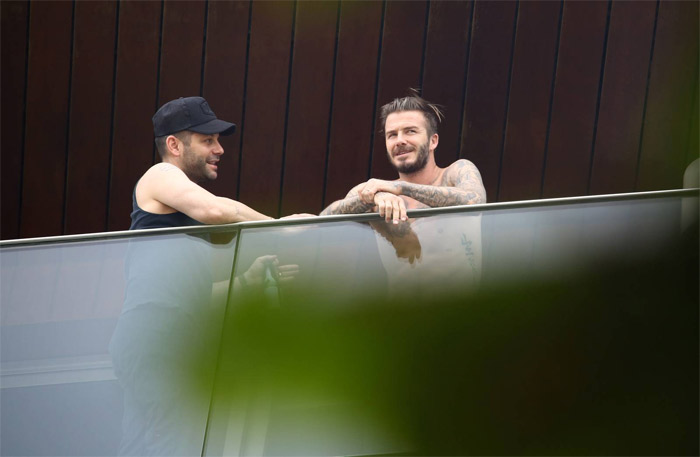 David Beckham aparece sem camisa em sacada de hotel