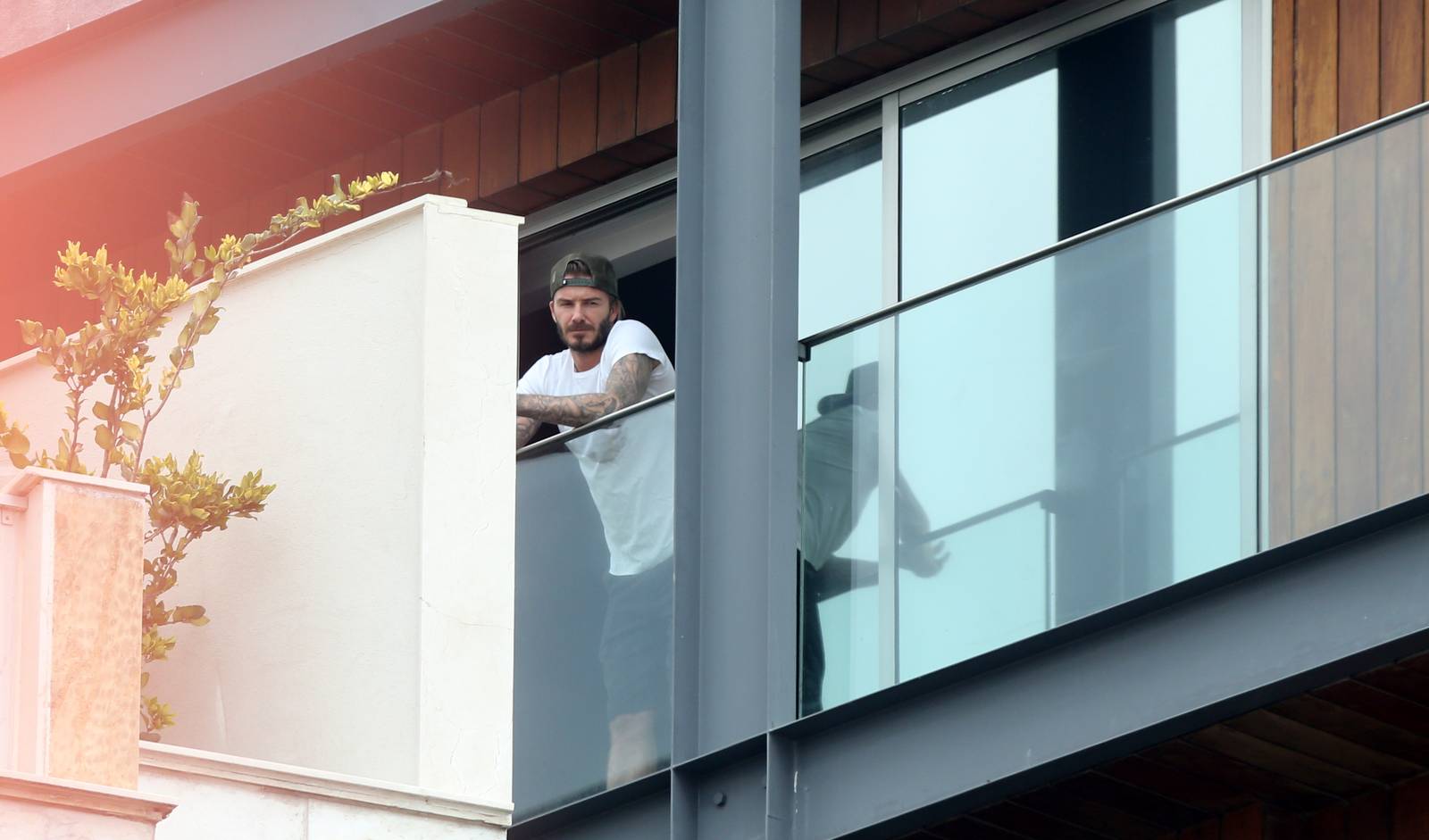 David Beckham aparece sem camisa em sacada de hotel