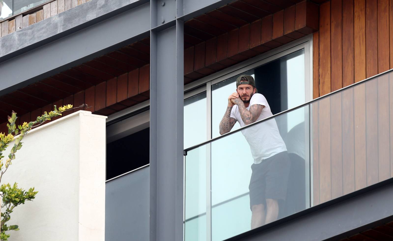 David Beckham aparece sem camisa em sacada de hotel