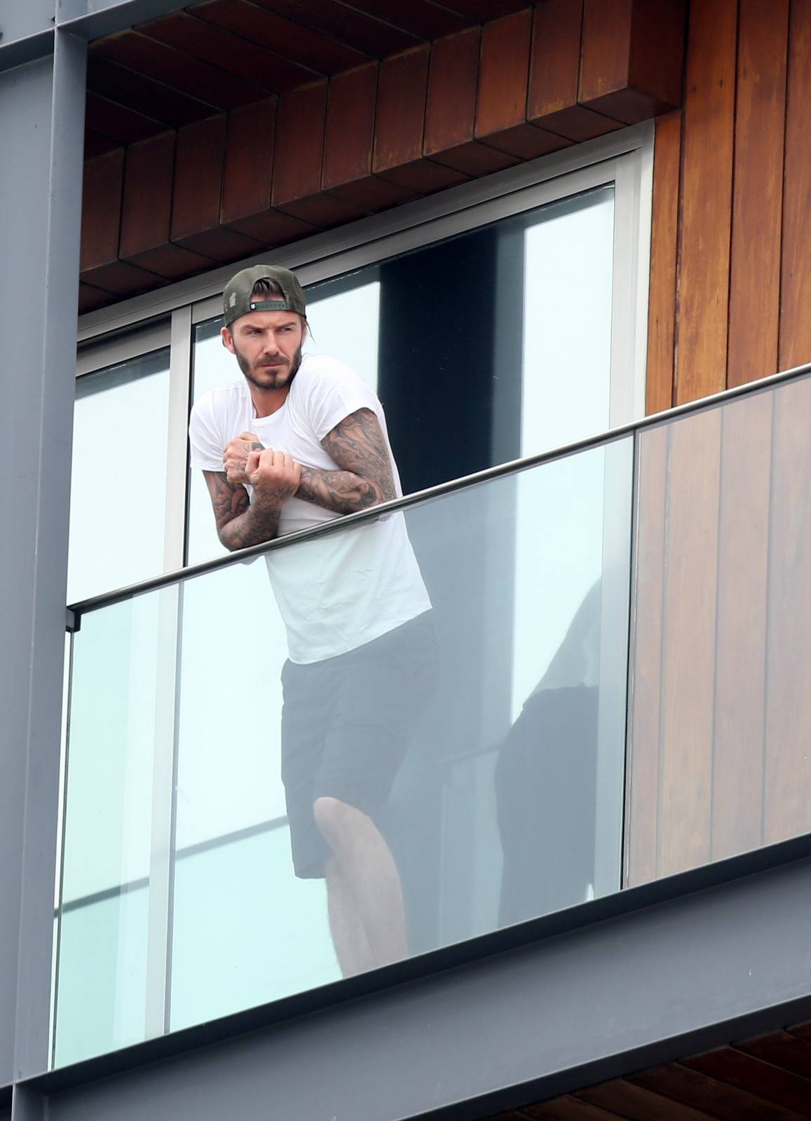 David Beckham aparece sem camisa em sacada de hotel