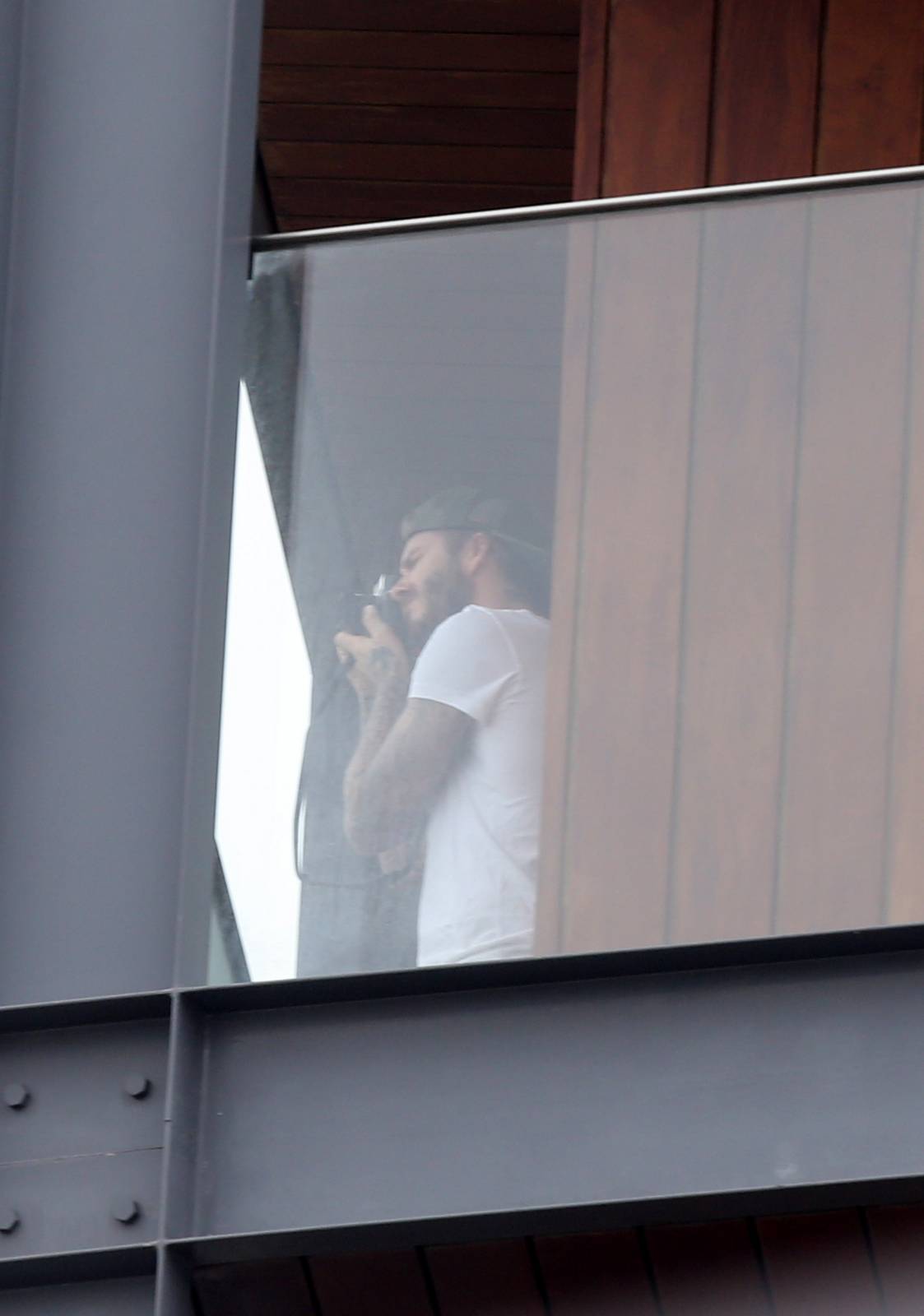 David Beckham aparece sem camisa em sacada de hotel