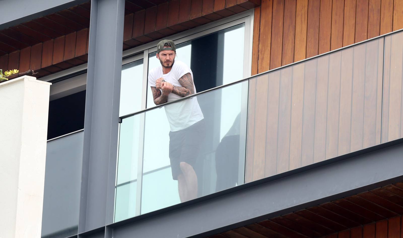 David Beckham aparece sem camisa em sacada de hotel