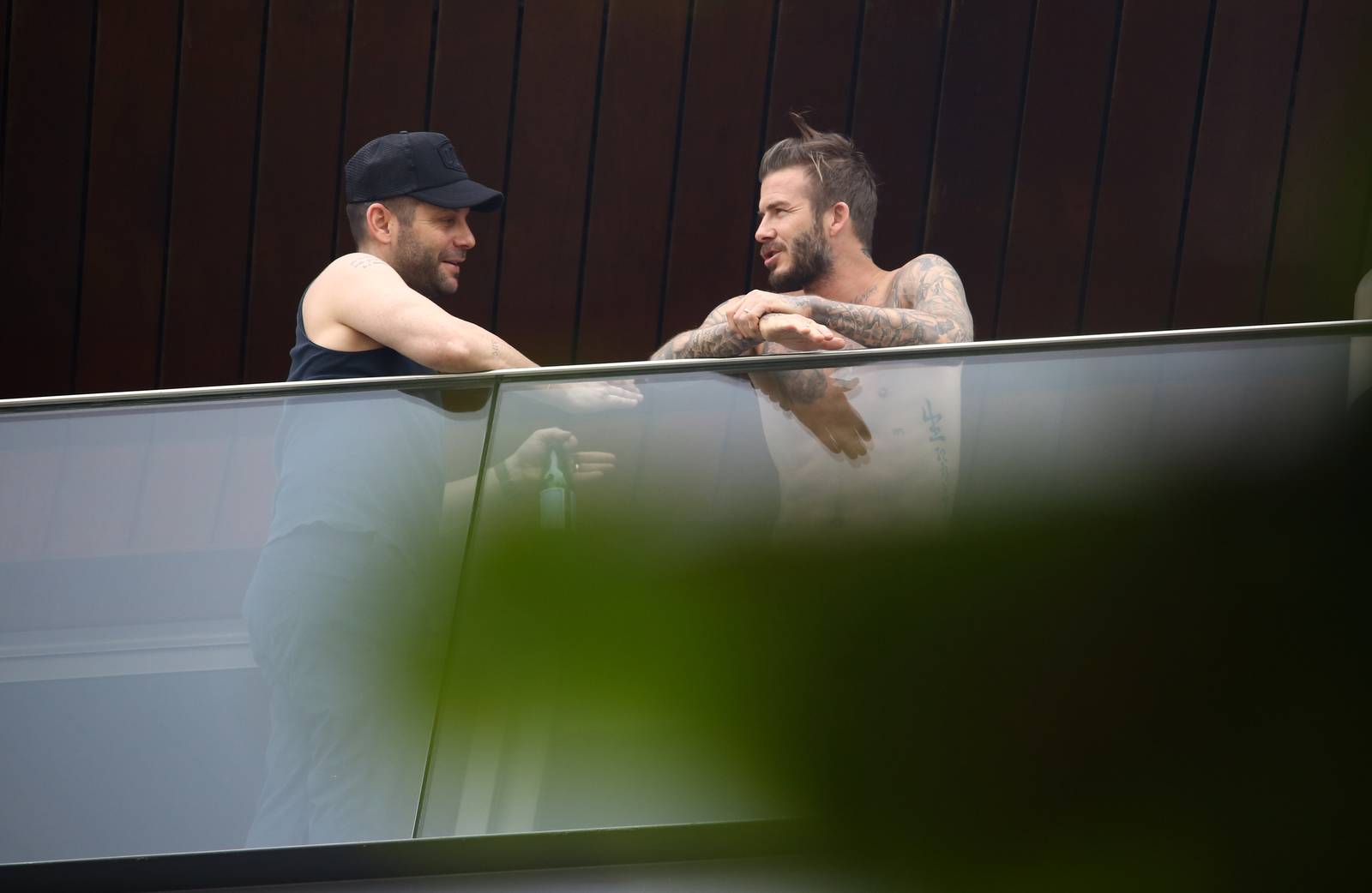 David Beckham aparece sem camisa em sacada de hotel