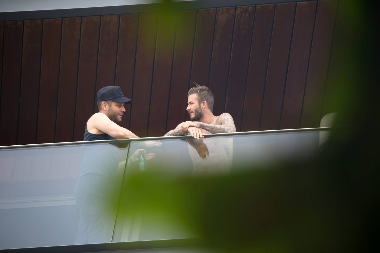 David Beckham aparece sem camisa em sacada de hotel