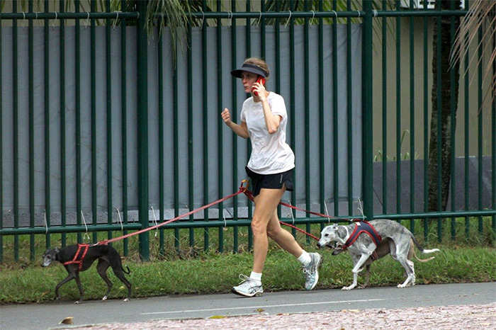 Betty Goffman corre com os três cachorros presos na cintura