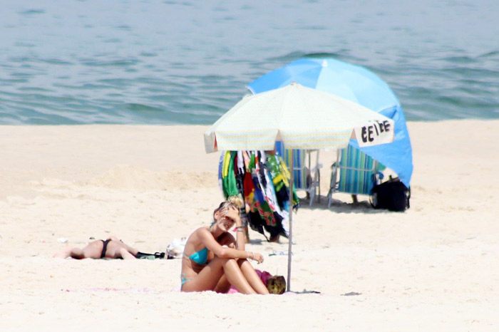 Yasmin Brunet toma sol e água de coco na praia 