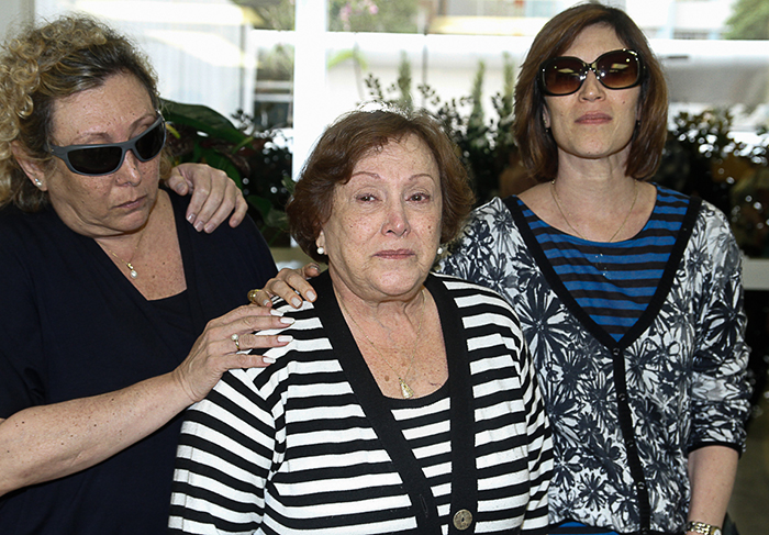 Nicette Bruno fala com a imprensa na porta do hospital, amparada pelos filhos