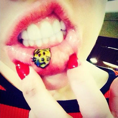 Miley Cyrus tatua gatinho triste na parte interna de seu lábio