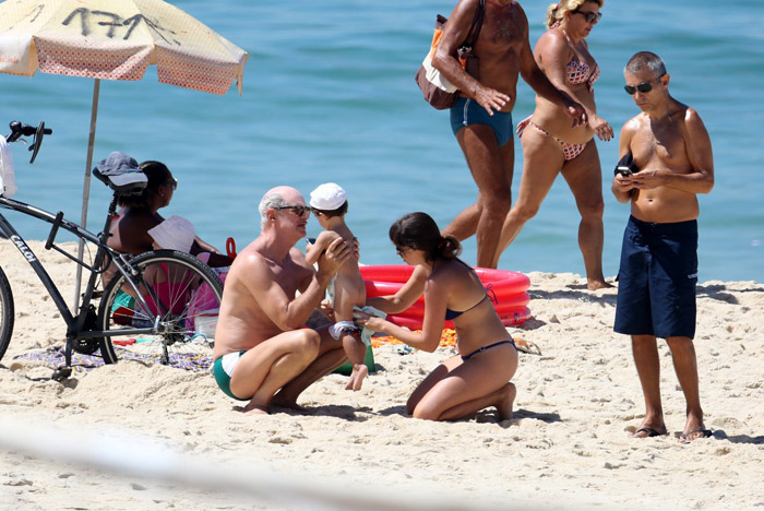 Marcos Caruso se diverte com o neto na praia do Leblon