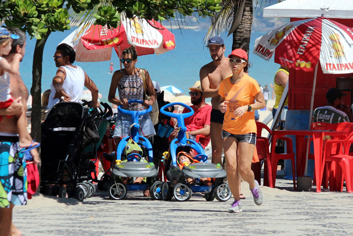 Marcelo Serrado e a mulher levam os gêmeos à praia