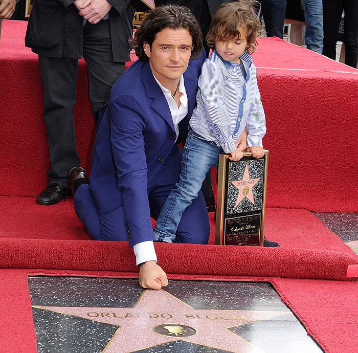 Orlando Bloom posa com o filho ao ganhar estrela na Calçada da Fama