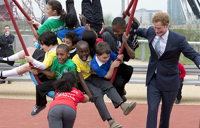 Príncipe Harry se diverte com crianças em visita ao Olympic Park
