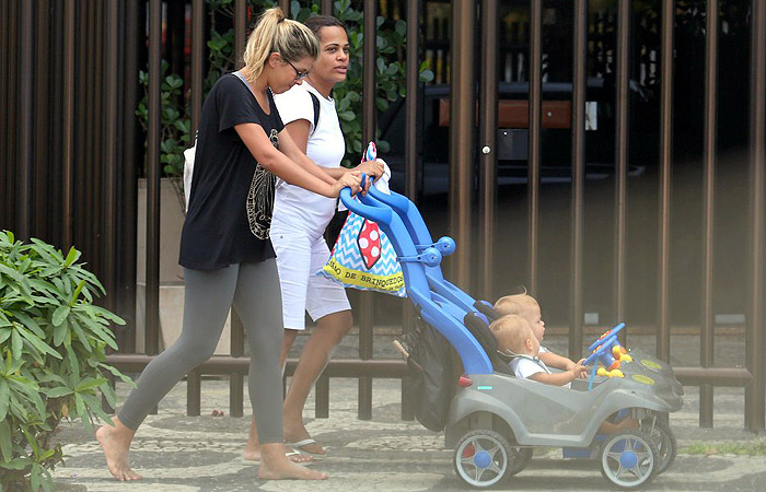 Com bolsa a tiracolo, Marcelo Serrado passeia com a família em Ipanema