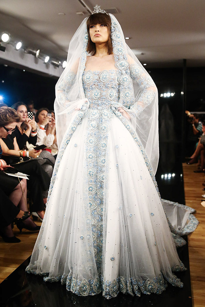 Vestido branco e clássico tem detalhes em pedra azul e usa tecido transparente para imitar tomara que caia